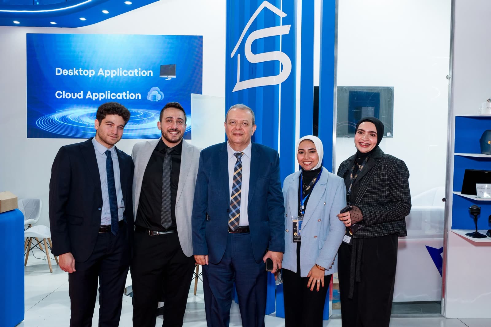 SWH colleagues beside the stand's desktop and cloud application panel at NEBU Expo 2024.