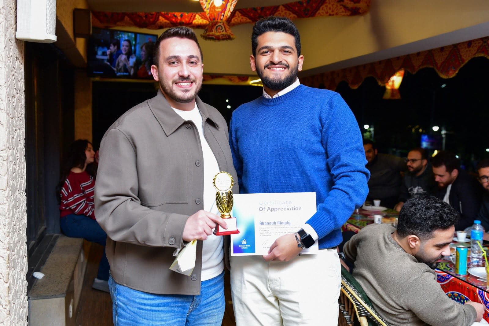 A team member receiving a trophy and certificate of appreciation at the Ramadan outing.